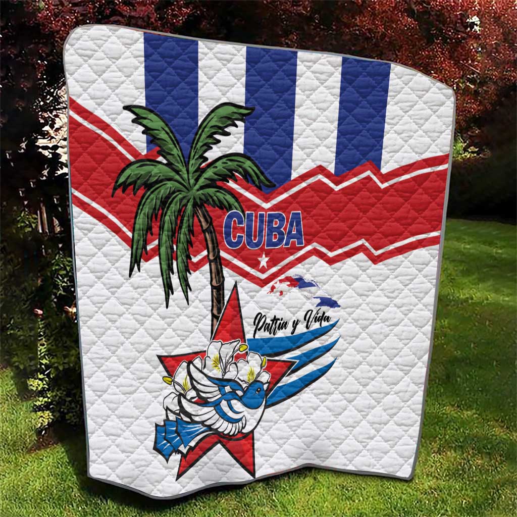 White quilt with Cuba text, palm tree, and bird graphic over blue/red stripe design.