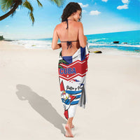 White Cuba-themed sarong worn as a wrap, featuring Cuba text and bird-and-palm artwork