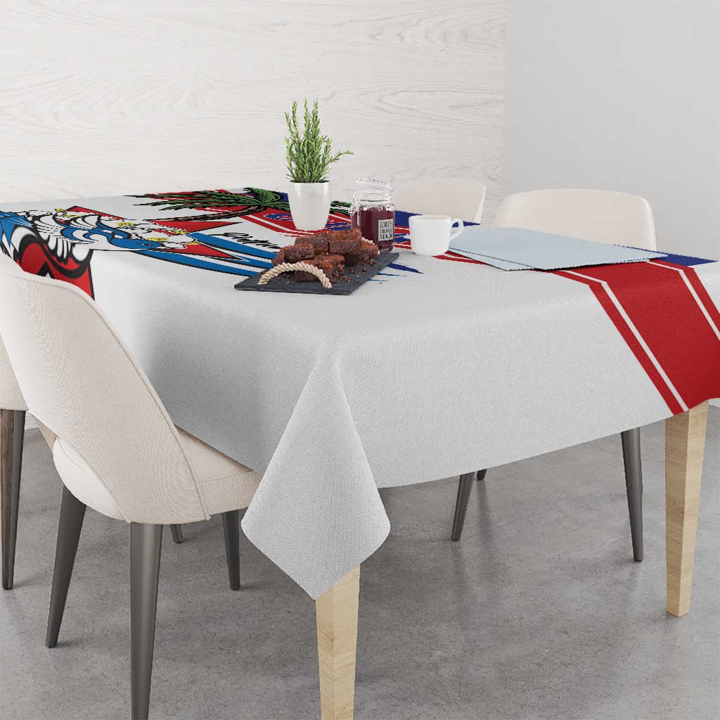 White tablecloth with Cuban bird graphic and red blue border draped over dining table