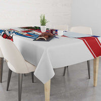 White tablecloth with Cuban bird graphic and red blue border draped over dining table