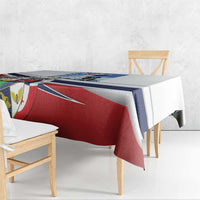 White printed tablecloth with red, blue, and crest graphic draped over table