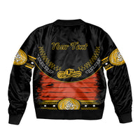 Black bomber jacket with orange graphic, gold trim, and “Your Text” print