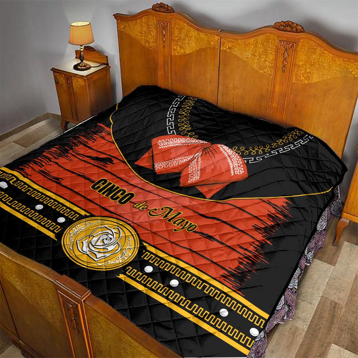 Charro quilt on bed, black quilted fabric with orange band, red bow, gold emblem