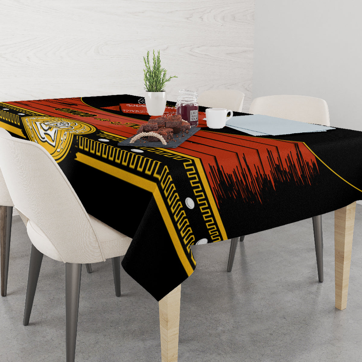 Black Cinco de Mayo tablecloth with gold geometric trim and red rays across tabletop