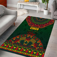 Green area rug with 'CINCO' and 'Mayo' lettering, red and yellow folk design