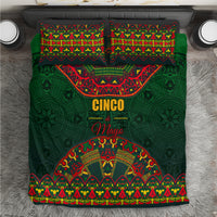 Green bedding set flat lay showing comforter with Cinco de Mayo text and folk motifs.