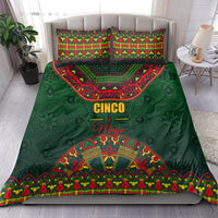 Green bedding set on bed with colorful folk pattern comforter and two matching pillowcases.