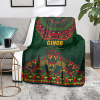 Green Cinco de Mayo throw blanket with bright mandala-style border, on sofa