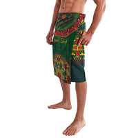 Green lavalava skirt with vivid Mexican folk print panels, side slit, worn at knee.