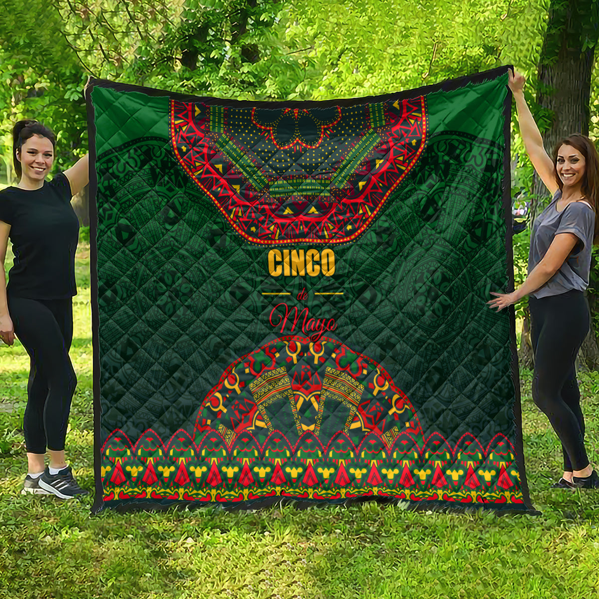 Green quilted blanket with red bandana top, 'Cinco' text, and colorful border