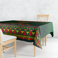 Green folk-pattern tablecloth draped over a dining table with colorful border