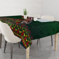Green tablecloth with colorful folk motifs, draped across a dining table