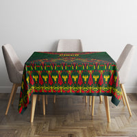Green folk-pattern tablecloth with colorful geometric stripes across a dining table