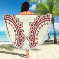 Round beige beach blanket with fringe, showing red and blue geometric corner motifs from the back