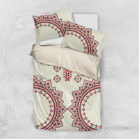 Beige bedding set laid flat with red and blue circular folk patterns and central vertical motif