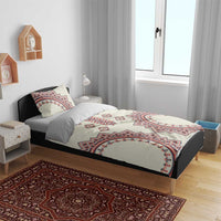 Beige bedding set on bed with red and blue traditional medallion pattern and matching pillow covers