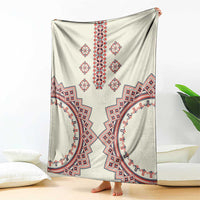 Beige throw blanket with centered red geometric motif and V-shaped border