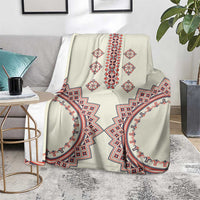 Beige patterned throw blanket with bold red and blue symmetrical motifs