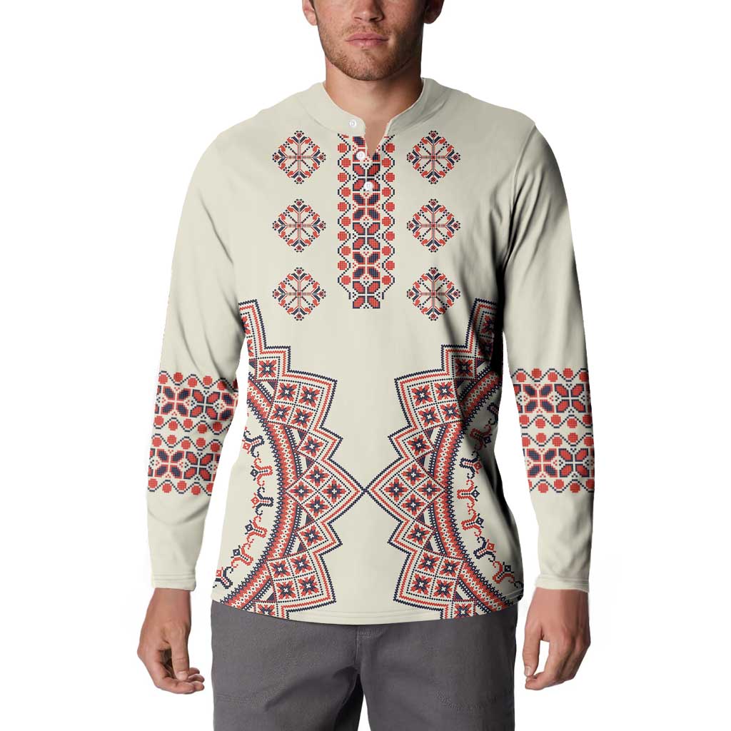Beige button sweatshirt on model with long sleeves and red-blue folk chest pattern