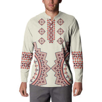 Beige button sweatshirt on model with long sleeves and red-blue folk chest pattern