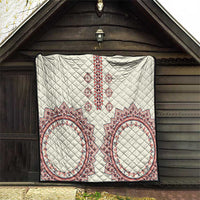 White quilt hung on wood wall with diamond stitching and red, blue, and white medallion borders
