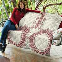 White quilt featuring diamond quilting and red, white, blue central cross and oval medallions
