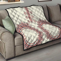 Traditional quilt draped over sofa: white diamond quilting with red and blue oval medallion design
