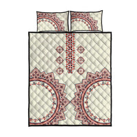 Beige quilt and two matching pillows with central red and blue traditional geometric embroidery