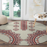 Beige round rug with large red, blue, and white geometric border and center motifs