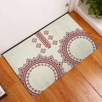 Beige rubber doormat with symmetrical red and blue floral geometric motif