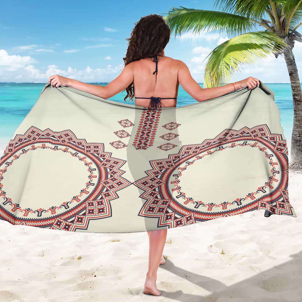 Beige sarong with large red and navy medallion prints, tied at sides.