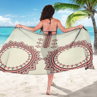 Beige sarong with large red and navy medallion prints, tied at sides.