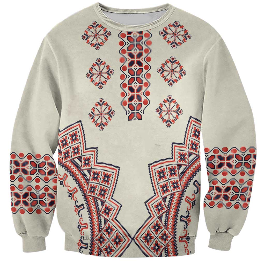 Beige crewneck sweatshirt with red and blue folk geometric pattern on front and sleeves