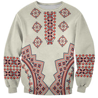 Beige crewneck sweatshirt with red and blue folk geometric pattern on front and sleeves