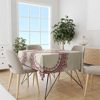 Beige tablecloth with red and blue geometric trim, laid on dining table