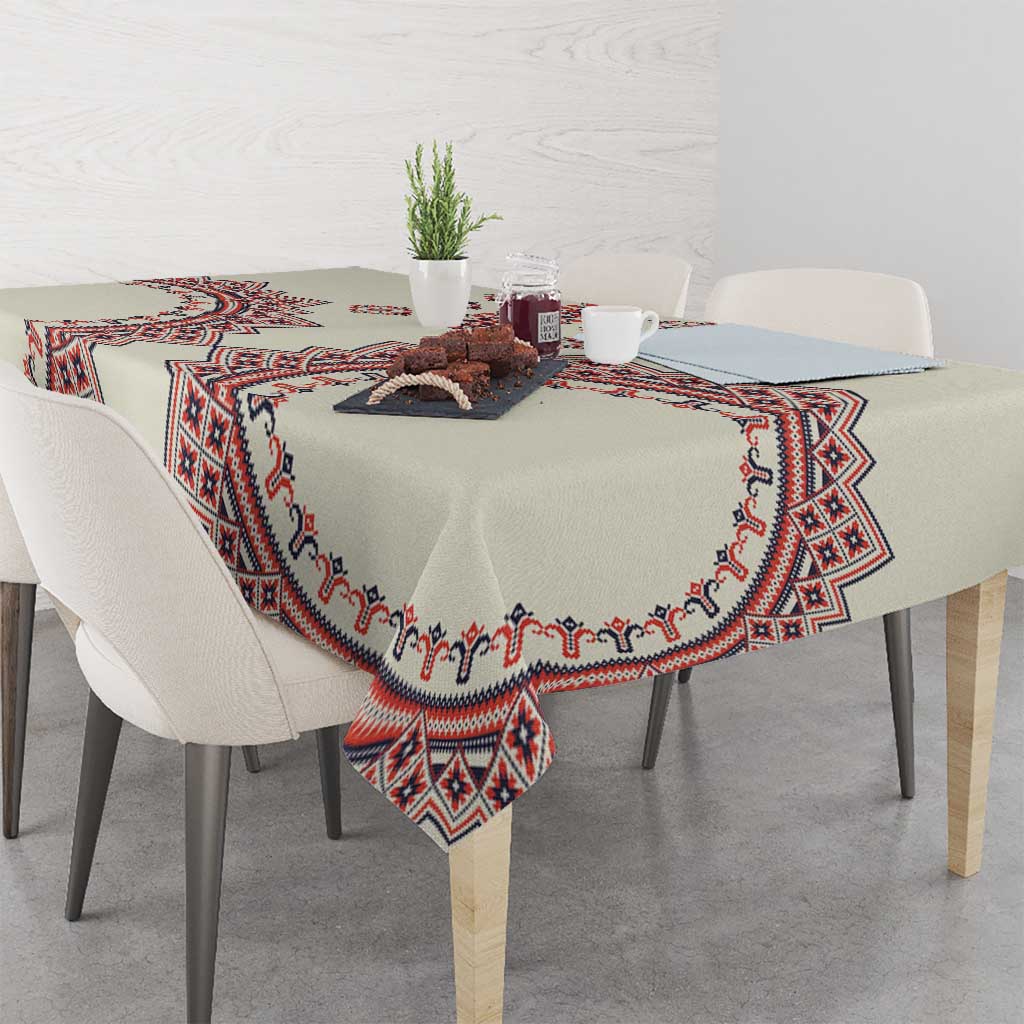 Beige tablecloth with red and blue border pattern and corner drape