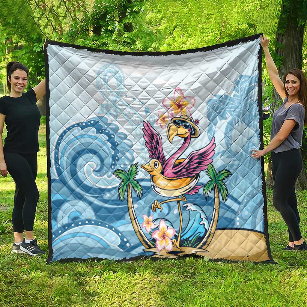 Blue tropical flamingo quilt laid on grass with quilted diamond pattern