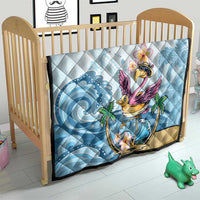 Blue tropical flamingo quilt on a wooden crib with plumeria and palm print