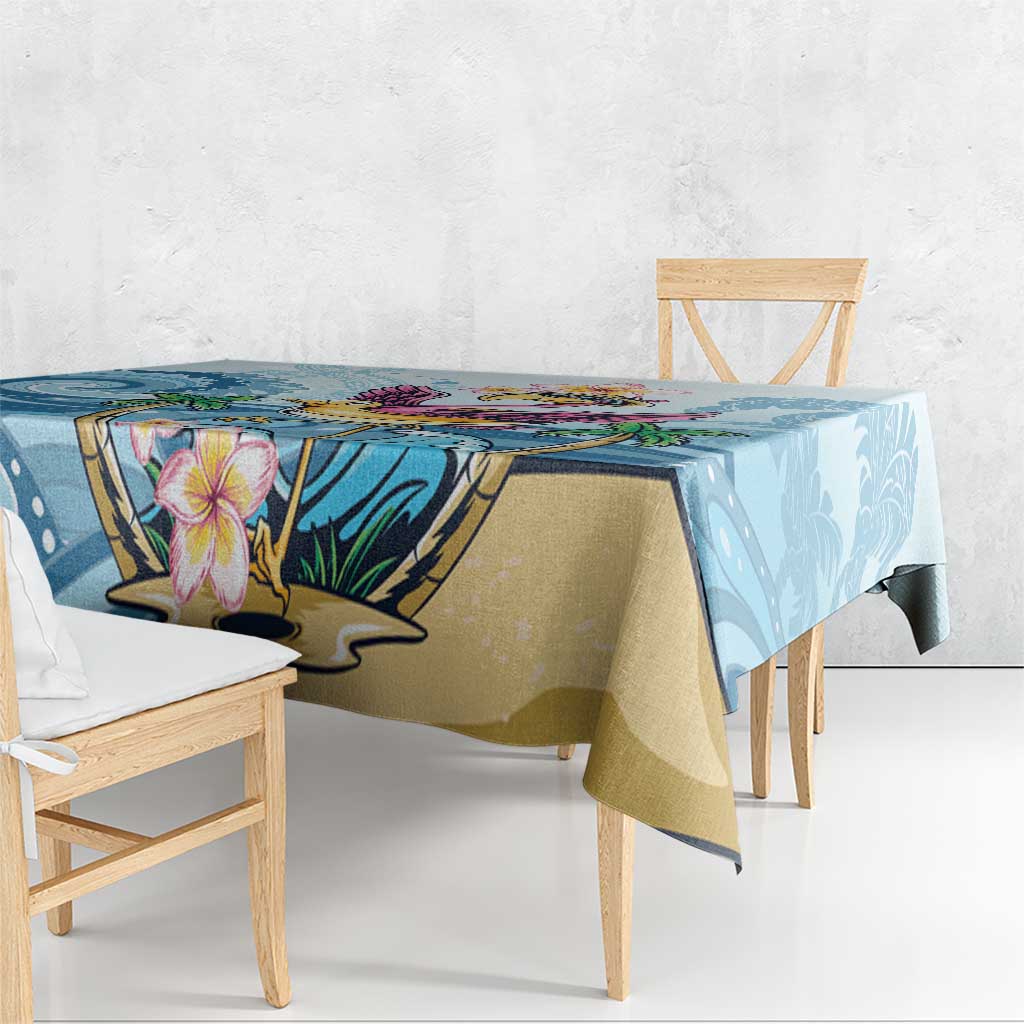 Blue tropical tablecloth with flamingo and plumeria flower graphic, draped down