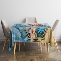 Blue tropical tablecloth with flamingo pedestal and plumeria flowers on dining table