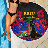 Round beach blanket draped near pool: Haiti text, red hibiscus on black, white fringe trim