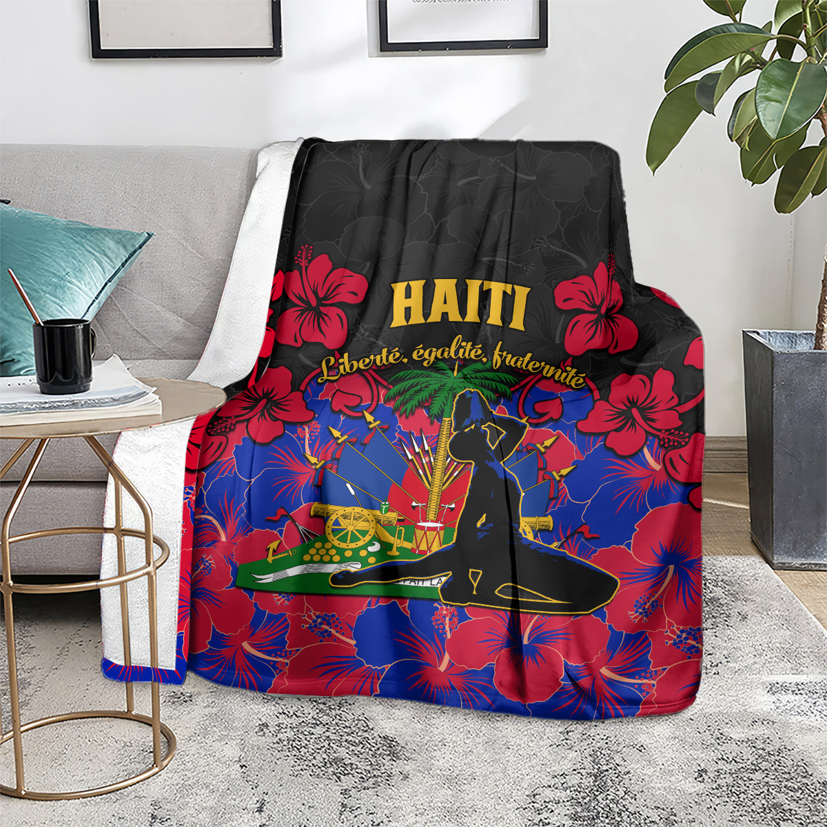 Haiti blanket draped on sofa, black background with red hibiscus, blue fireworks pattern and gold HAITI