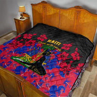 Black Haiti-themed quilt on bed with red hibiscus flowers and central silhouette emblem