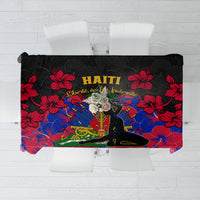 Black tablecloth with red hibiscus flowers and “HAITI” lettering over a blue scene.