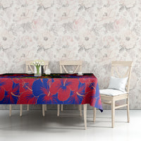 Black and red with blue hibiscus tablecloth, spread across a dining table.