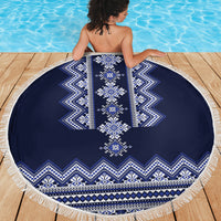 Round navy blue beach blanket with white folk embroidery pattern and long fringe
