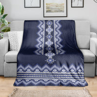 Ukrainian folk pattern blanket draped on couch, dark navy with blue and white zigzags