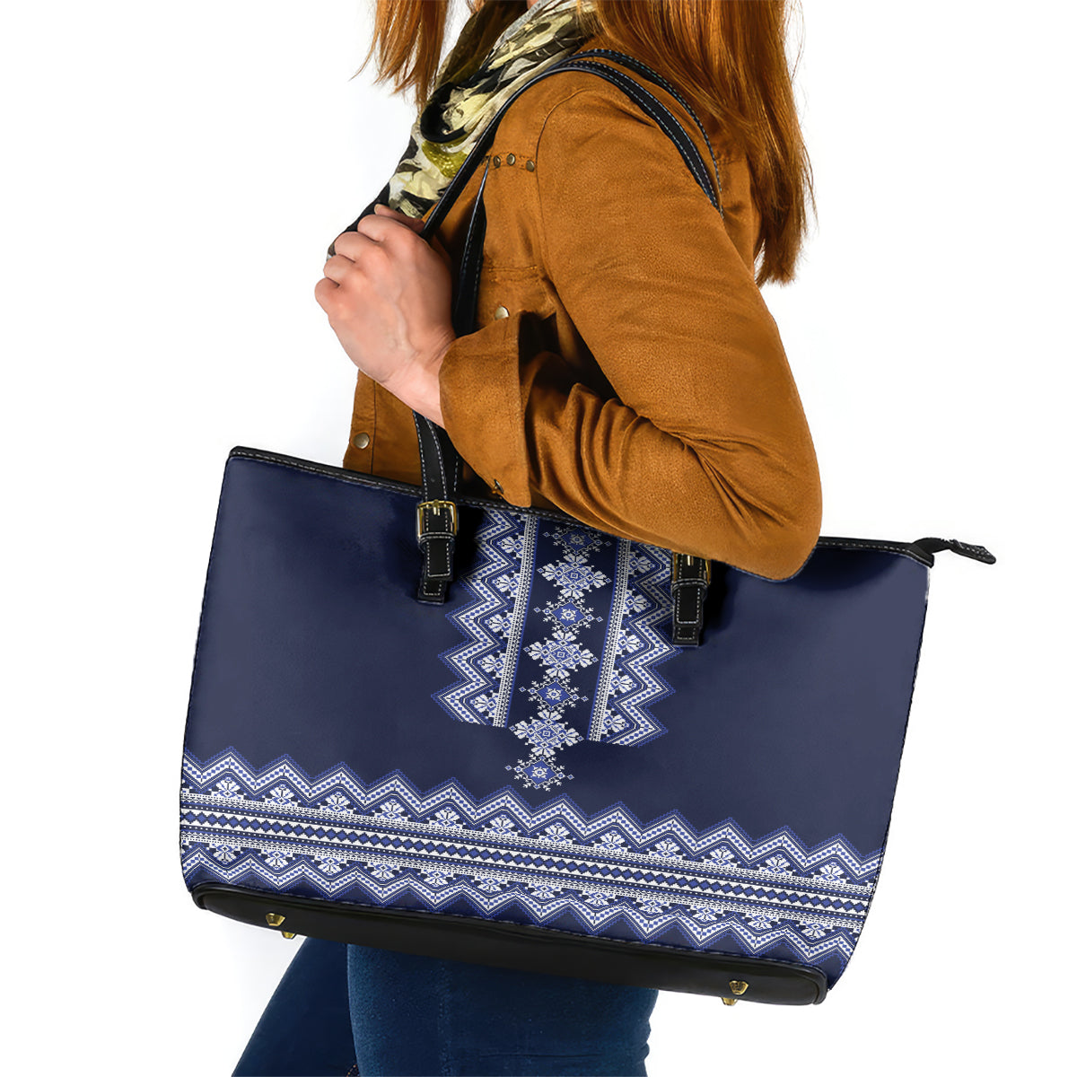Navy blue leather tote bag with white-blue folk stripe pattern, top zipper and dual handles