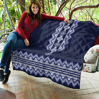 Navy blue quilt draped over sofa, showing white-blue folk panel and zigzag border
