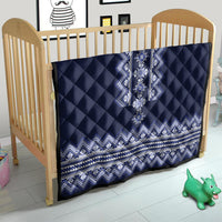 Navy blue quilt on a crib with white-blue folk geometric panel and zigzag trim